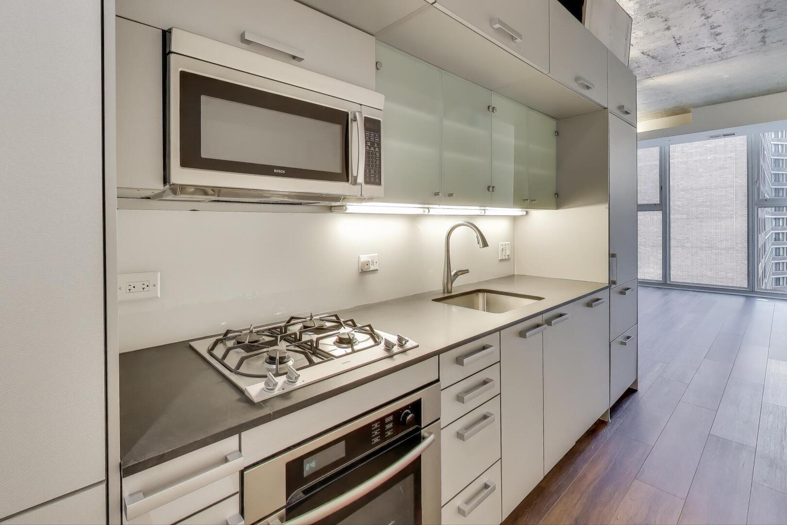 550 North St Clair Street, Unit 1303 Chicago, IL 60611 - Photo 12 of 20 a kitchen with a stove and a microwave