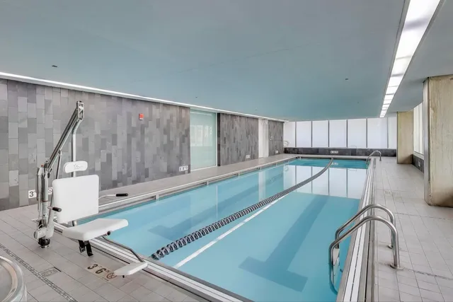 a large white kitchen with kitchen island granite countertop a large window