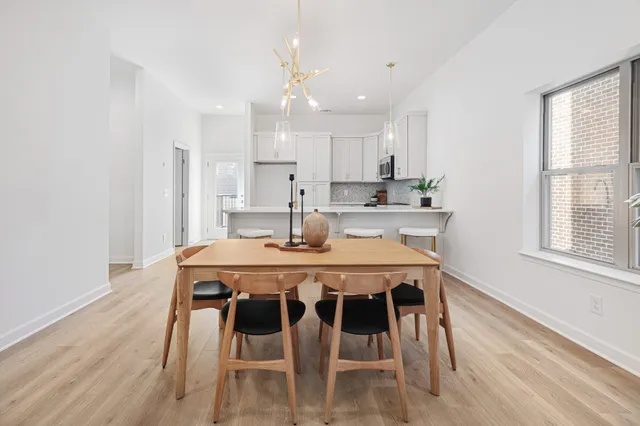 a dining room with a table chairs and kitchen view