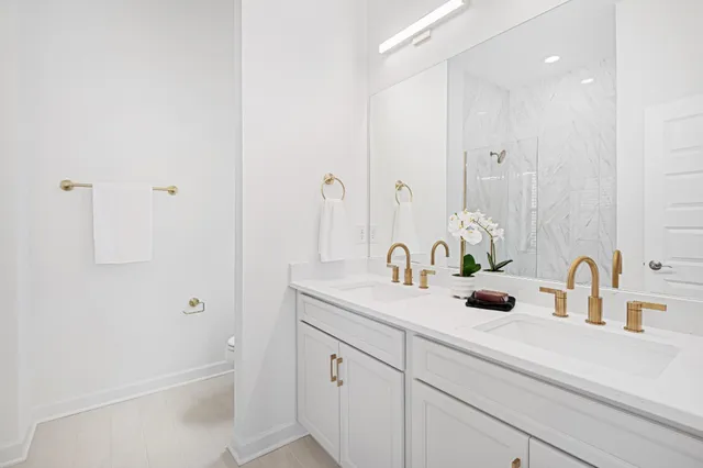 a bathroom with a sink and mirror with shower