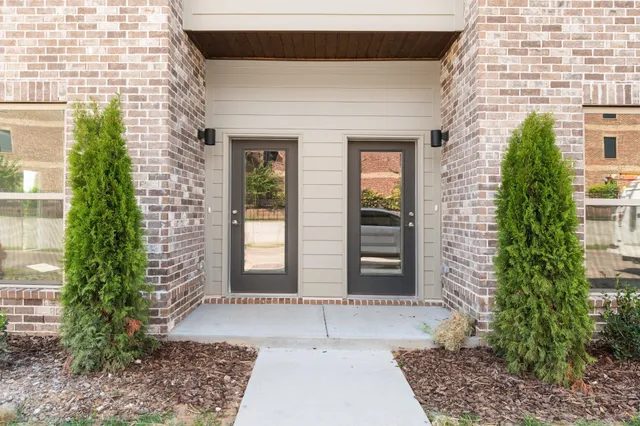 a view of a brick house with plants