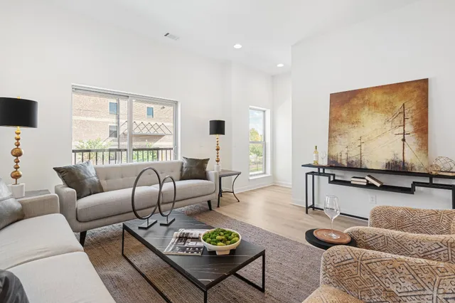 a living room with furniture a rug and a large window