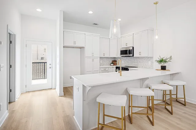 a kitchen with kitchen island white cabinets and stainless steel appliances