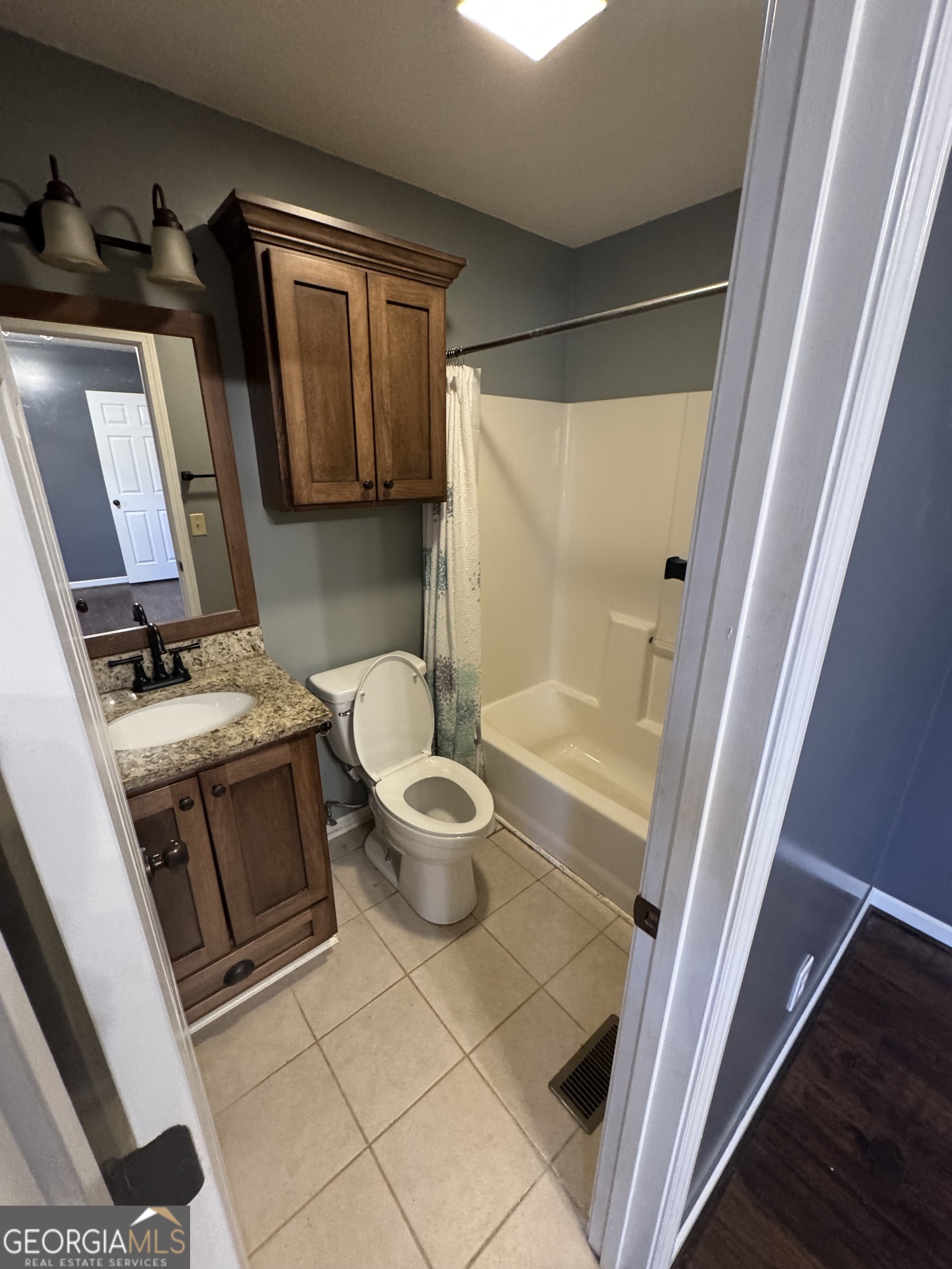 813 Normandy Trail Lavonia, GA 30553 - Photo 12 of 32 a bathroom with a granite countertop sink toilet and shower