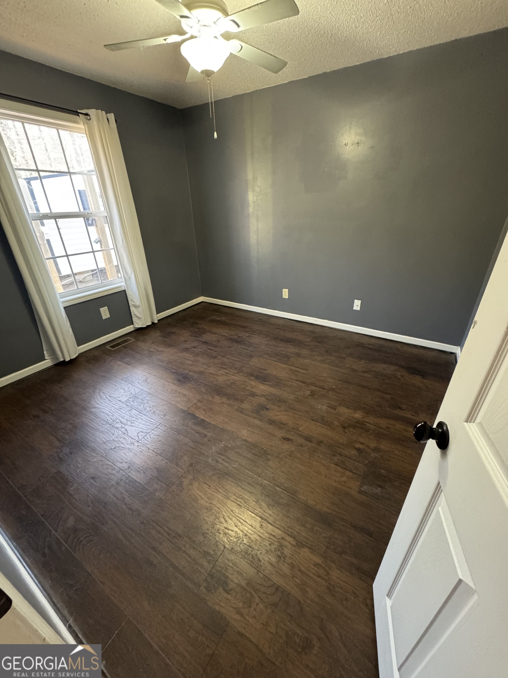813 Normandy Trail Lavonia, GA 30553 - Photo 19 of 32 an empty room with wooden floor and windows