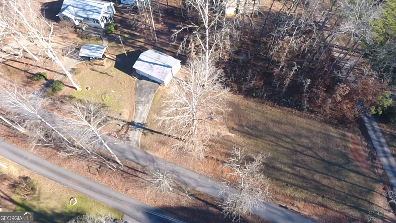813 Normandy Trail Lavonia, GA 30553 - Photo 20 of 32 a backyard of a house with large trees and wooden fence