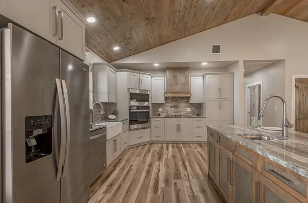 a kitchen with white cabinets and appliances