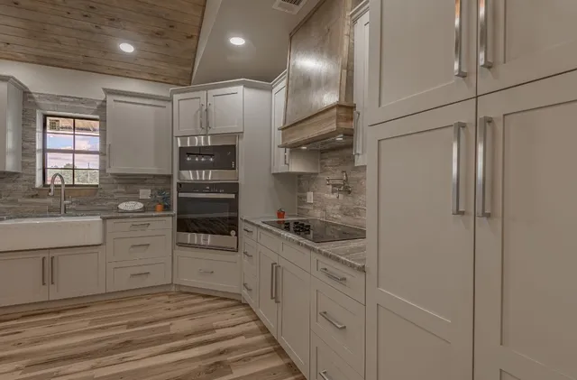 a kitchen with white cabinets and appliances