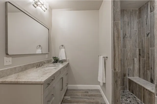 a bathroom with a granite countertop sink and a mirror