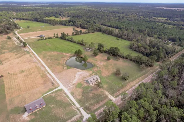 an aerial view of a house with a yard and lake
