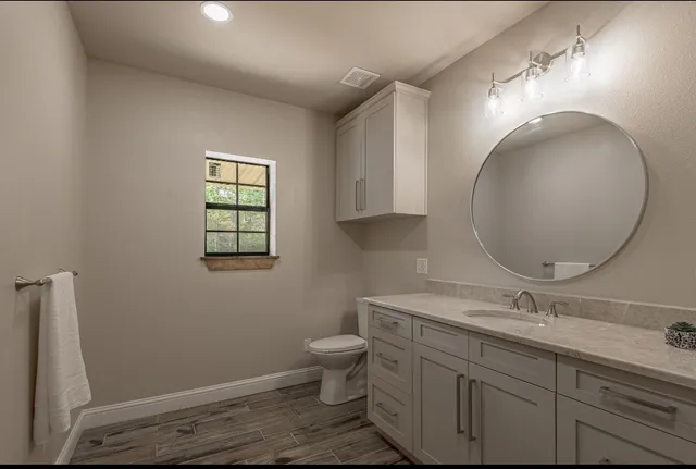 a bathroom with a toilet a sink and mirror
