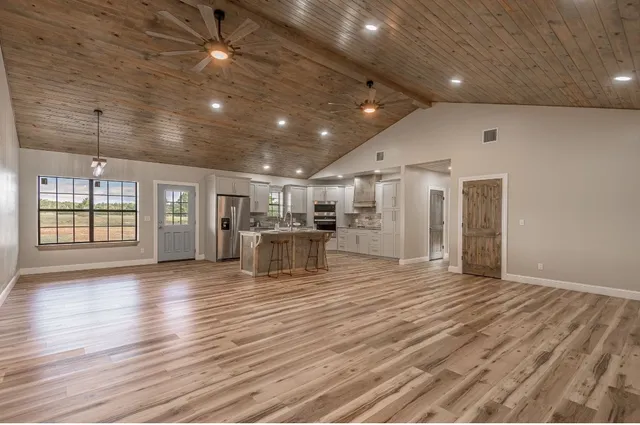 a view of an empty room with wooden floor