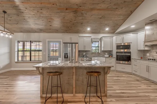 a kitchen with stainless steel appliances granite countertop a sink and a refrigerator