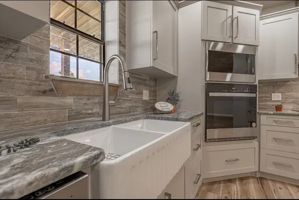 a kitchen with white cabinets and stainless steel appliances