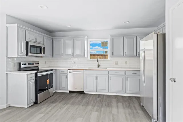 a kitchen with appliances cabinets and a sink