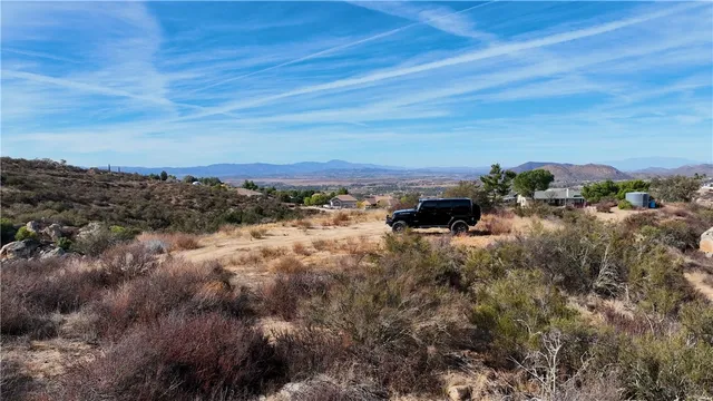 an aerial view of house with yard and mountain view in back