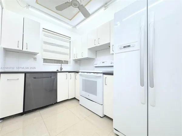 a kitchen with white cabinets stainless steel appliances and sink