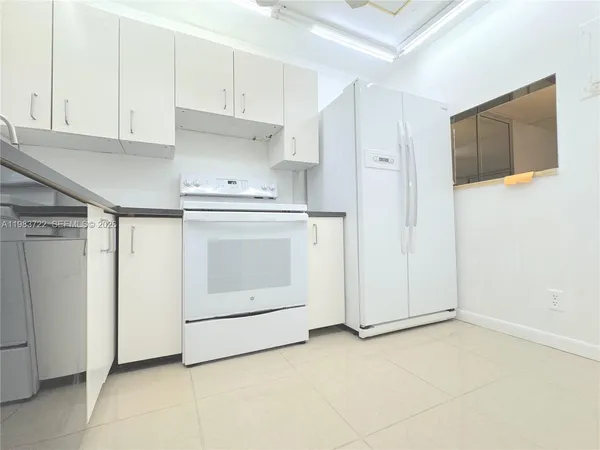 a kitchen with cabinets and white appliances