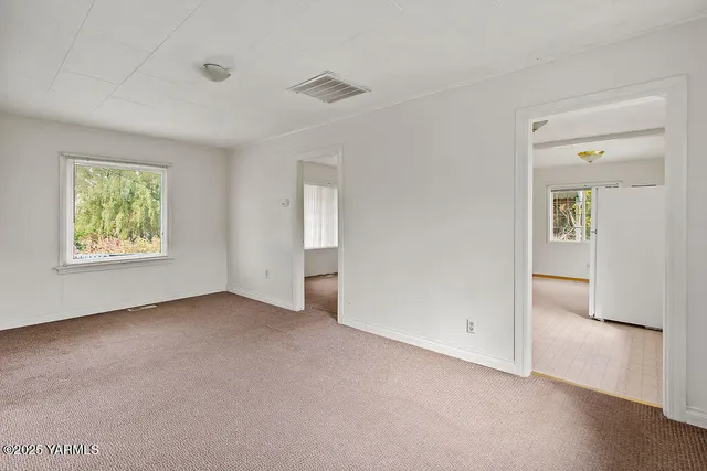 an empty room with windows and closet