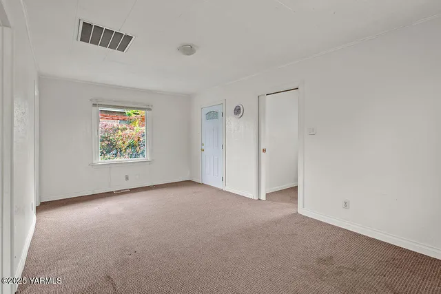 an empty room with windows and ceiling fan