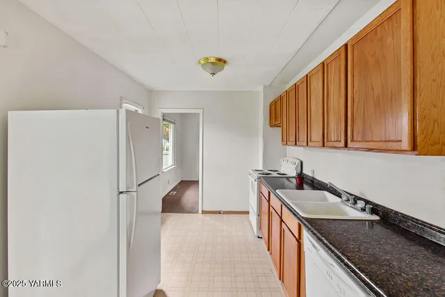 a kitchen that has a sink a stove and a refrigerator