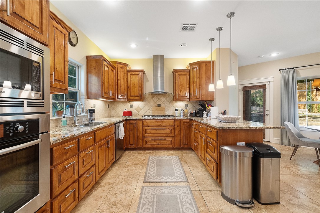 a large kitchen with stainless steel appliances kitchen island granite countertop a large counter top and stove