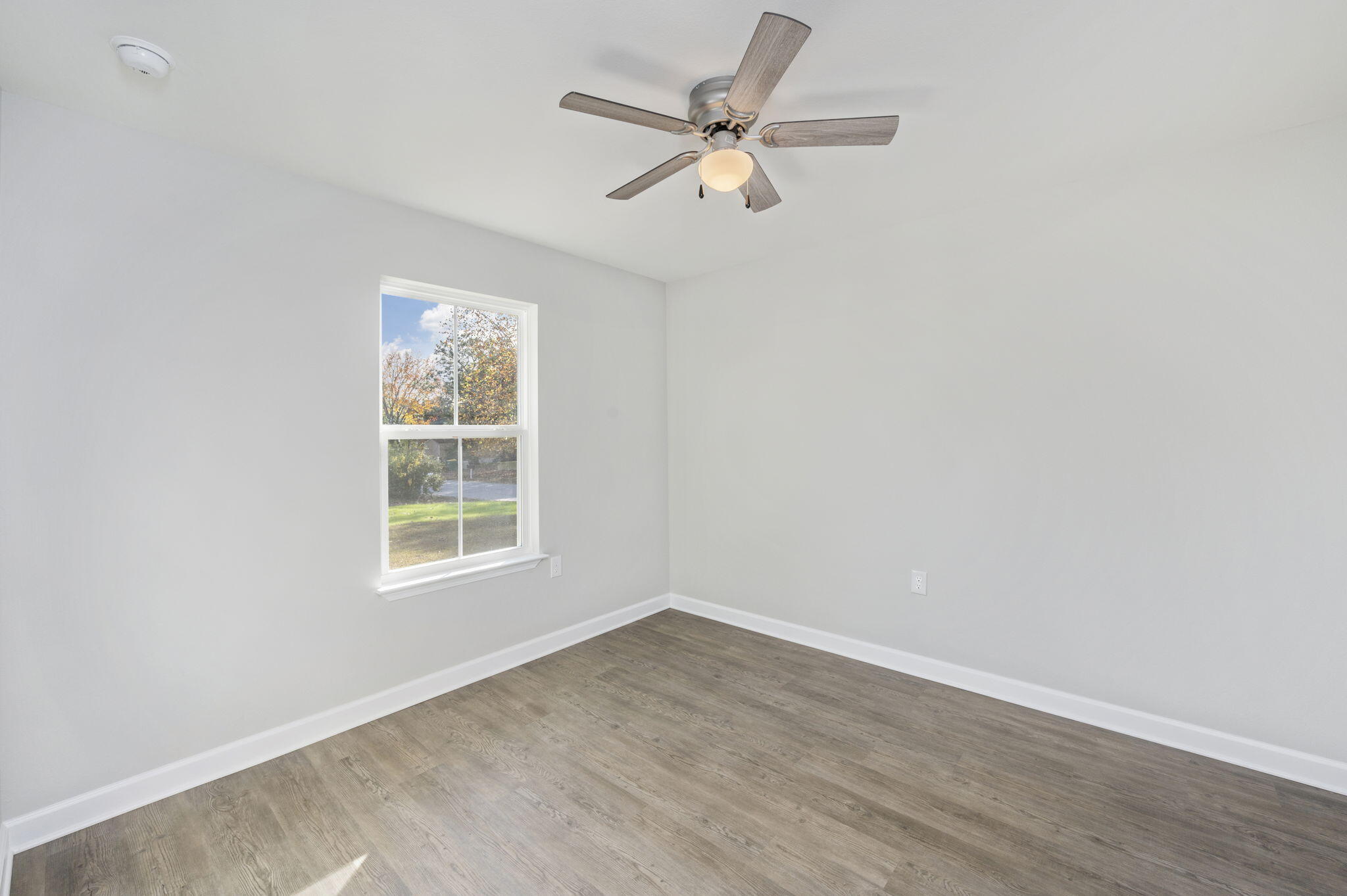 1000 Valley Road Crestview, FL 32539 - Photo 16 of 30 an empty room with wooden floor ceiling fan and windows