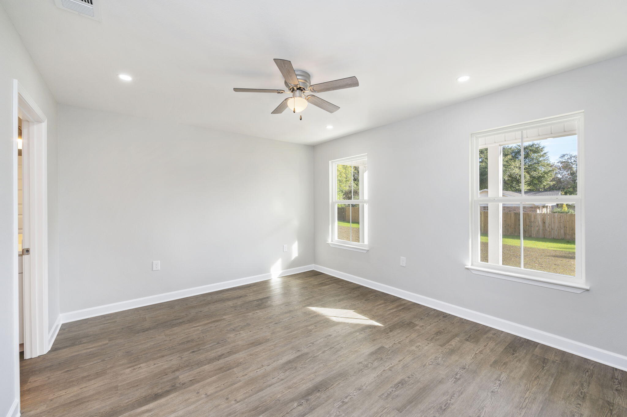 1000 Valley Road Crestview, FL 32539 - Photo 20 of 30 an empty room with wooden floor ceiling fan and windows