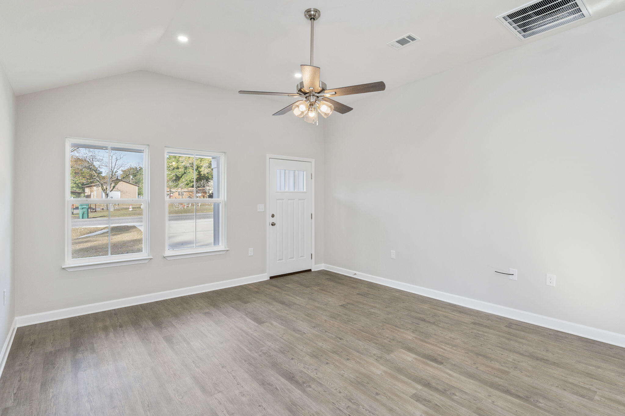 1000 Valley Road Crestview, FL 32539 - Photo 8 of 30 an empty room with wooden floor chandelier fan and windows