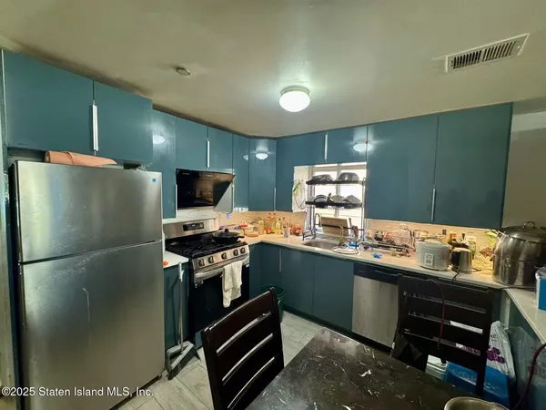 a kitchen with stainless steel appliances granite countertop a refrigerator and a stove top oven