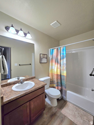 601 West 150 North, Unit 25 Springville, UT 84663 - Photo 23 of 29 Bathroom featuring a wood-finish vanity with an integrated sink, a built-in bathtub with a shower, and wood-finish flooring