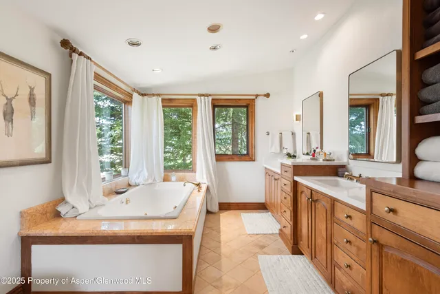 a spacious bathroom with a tub sink and mirror