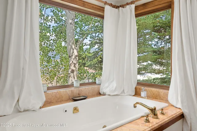 a bath tub sitting in a bathroom next to a window