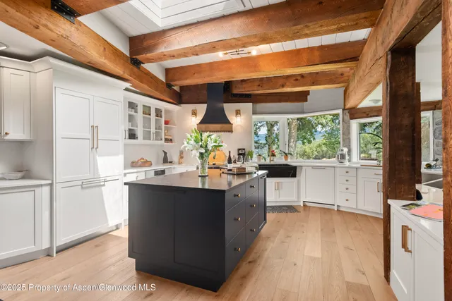 a kitchen with stainless steel appliances a sink cabinets and wooden floor