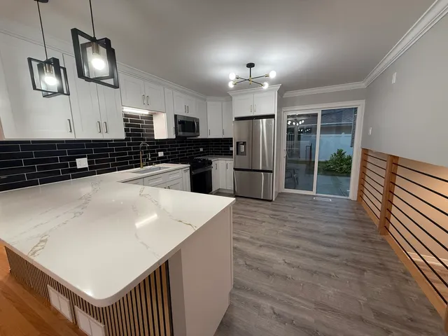 a kitchen with stainless steel appliances a refrigerator and a stove top oven
