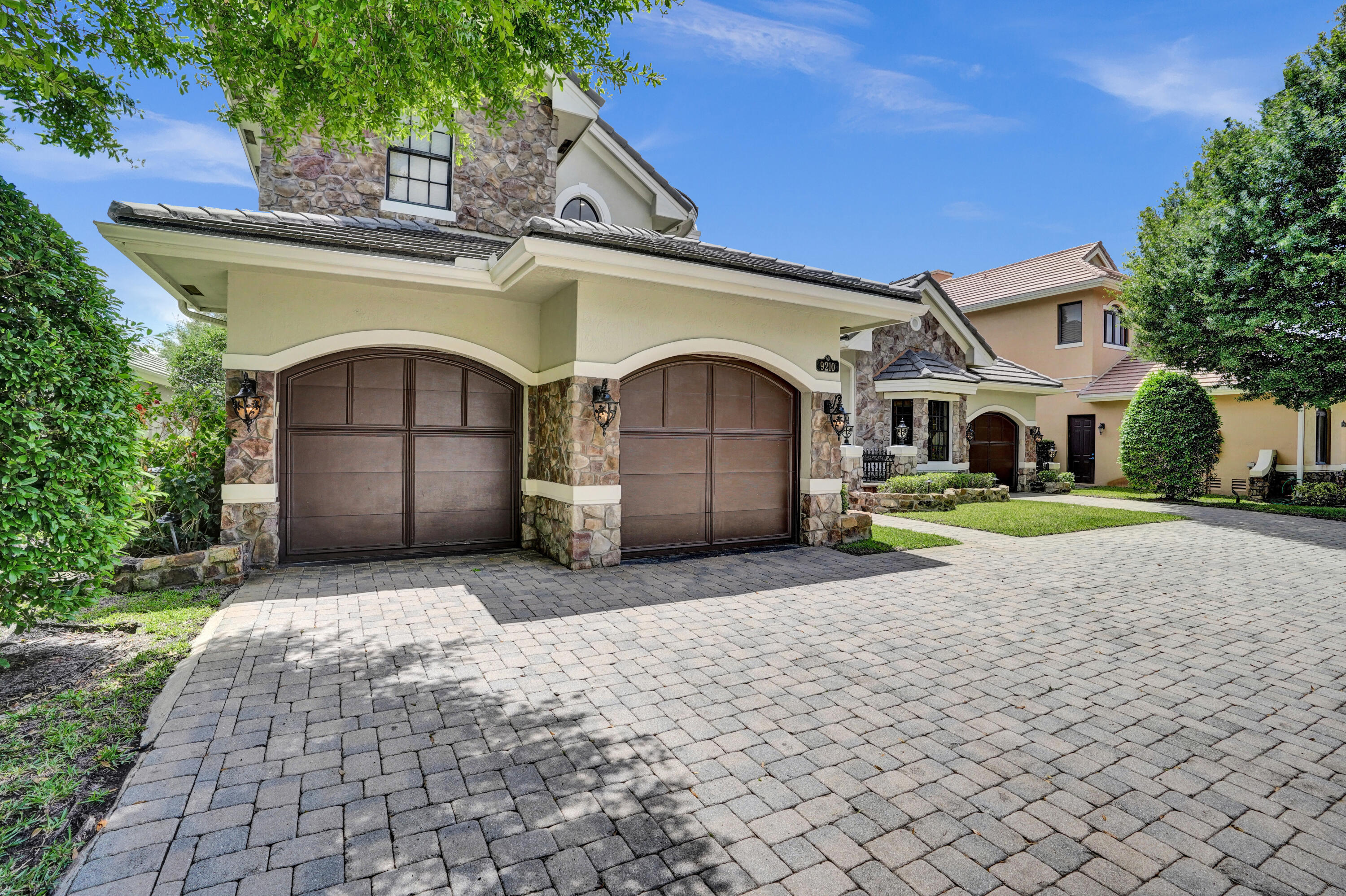 9210 Equus Circle Boynton Beach, FL 33472 - Photo 4 of 75 a front view of a house with a garden and trees