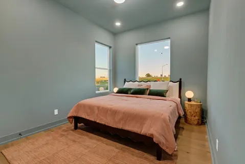 a bedroom with two beds and a large window