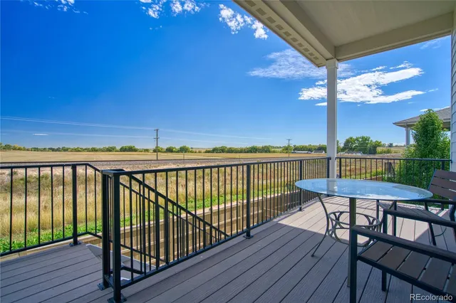 a view of a balcony with wooden floor and outdoor seating