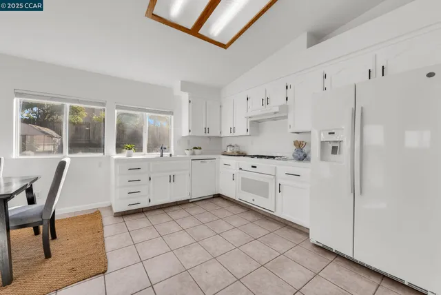 a kitchen with cabinets and chairs in it