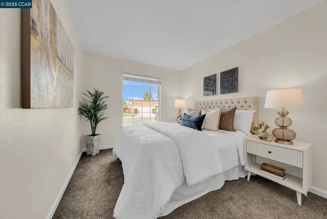 a bedroom with a bed and a lamp on dresser