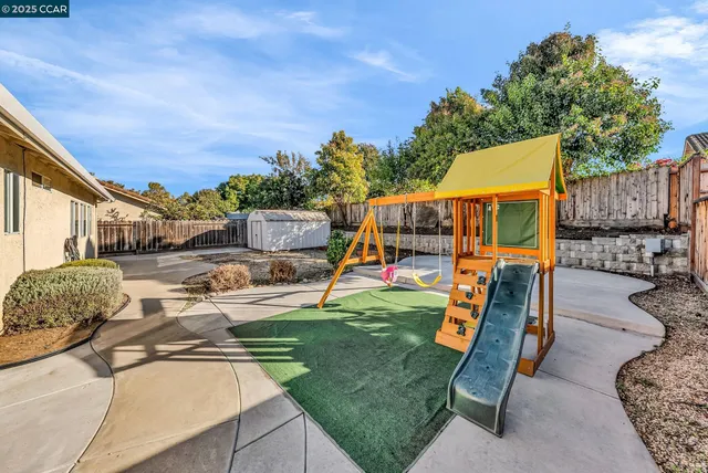 a view of a patio with table and chairs with wooden floor and fence