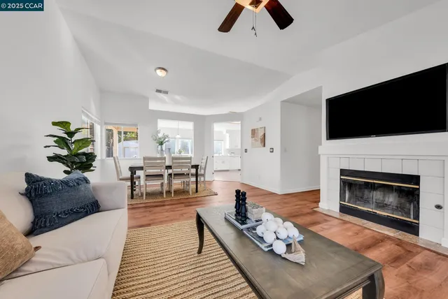 a living room with furniture a fireplace and a flat screen tv