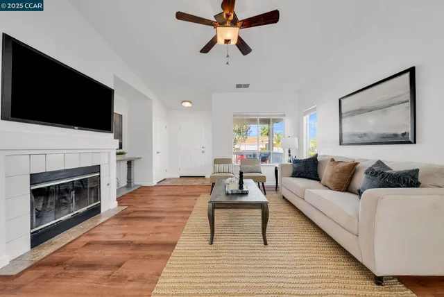 a living room with furniture a fireplace and a flat screen tv