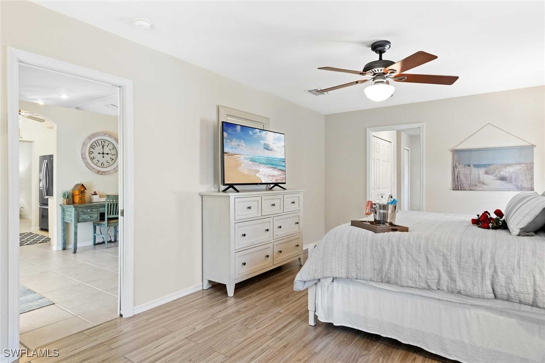 4810 Southwest 25th Place Cape Coral, FL 33914 - Photo 13 of 29 a bedroom with a bed and a chandelier