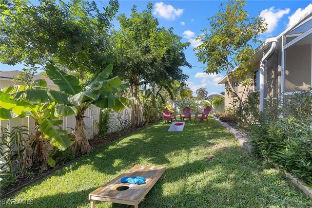 a view of a backyard with table and chairs and potted plants