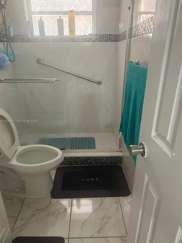 a bathroom with a toilet and a shower