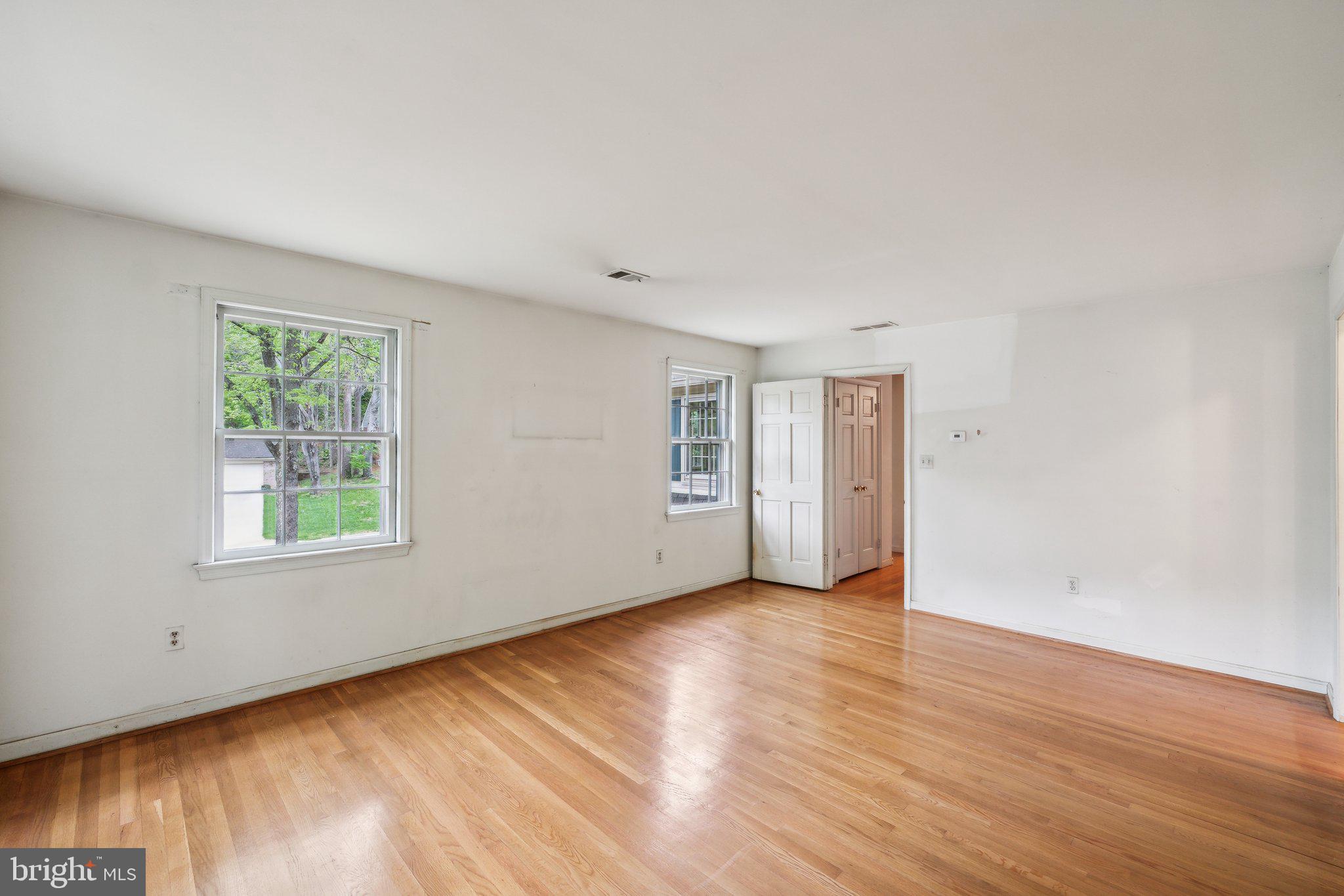 7604 Hackamore Drive Potomac, MD 20854 - Photo 16 of 56 an empty room with wooden floor and windows