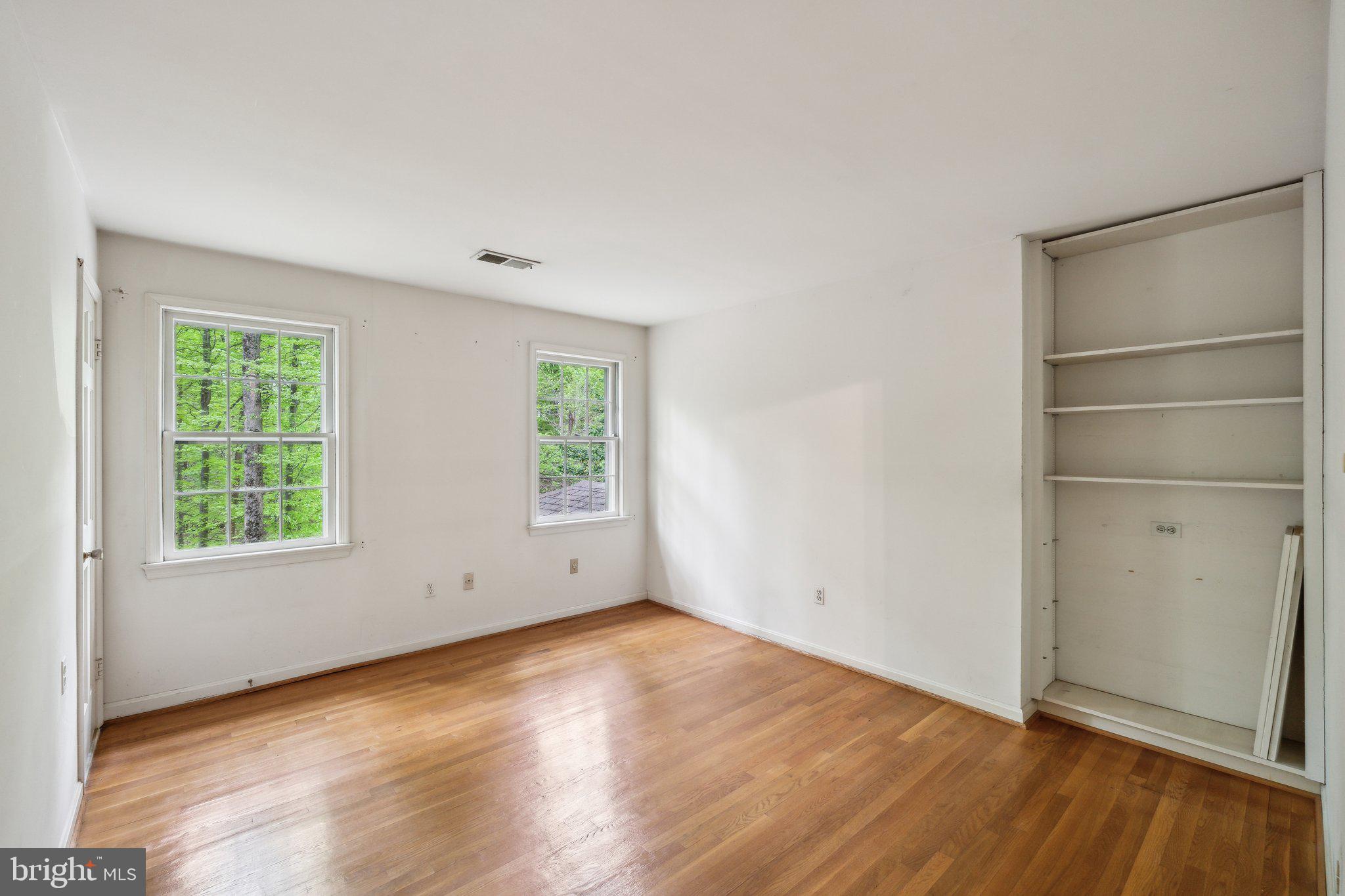 7604 Hackamore Drive Potomac, MD 20854 - Photo 20 of 56 an empty room with wooden floor cabinet and windows