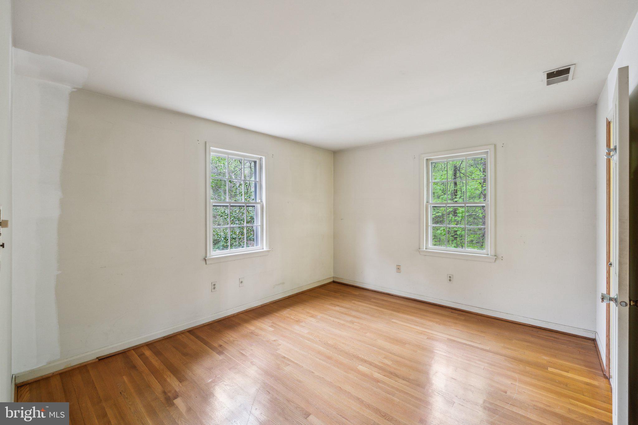 7604 Hackamore Drive Potomac, MD 20854 - Photo 24 of 56 an empty room with wooden floor and windows