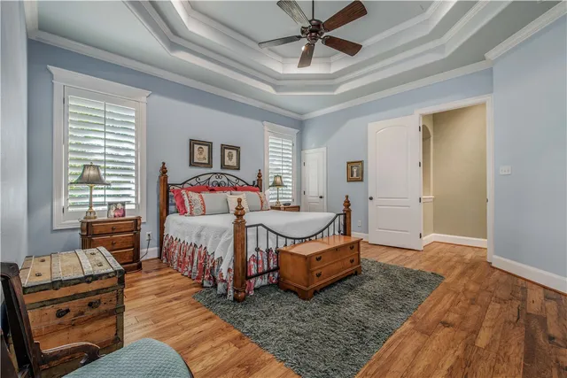 a living room with furniture large windows and wooden floor